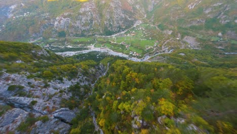 drone proximity flight down a mountain towards the village of theh in albania in autumn