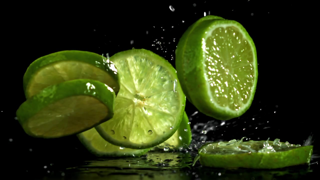 Vibrant Lime Slices Falling and Splashing on Black Background