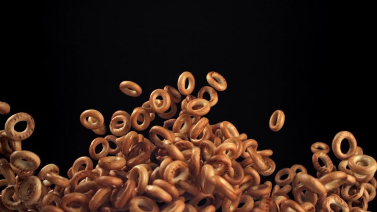 Rallentatore di bagel che cadono e si accumulano su sfondo nero.