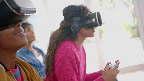 happy diverse group of teenage friends with vr headsets playing video games at home, slow motion