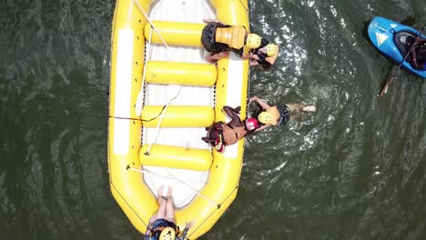 rafting instructor helping tourists to board the rafting boat