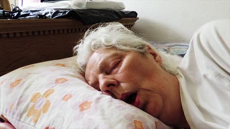 anciana soñolienta durmiendo en la cama - disparo constante de mano