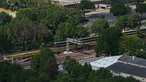 tomada de zoom aéreo de un tren estadounidense en el ferrocarril en la ciudad de atlanta llegando a la estación de tren - toma amplia desde arriba