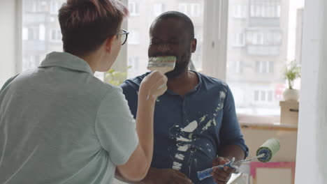 una pareja feliz pintando paredes.
