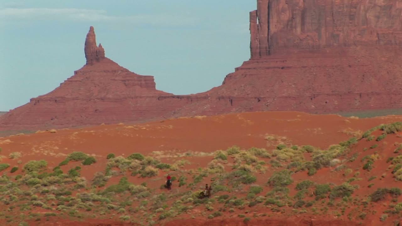 애리조나에 있는 모뉴먼트 밸리 부족 공원을 달리는 카우보이의 긴 샷
