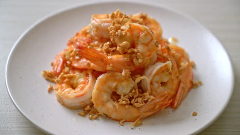 fried shrimps or prawns with garlic on white plate - seafood style