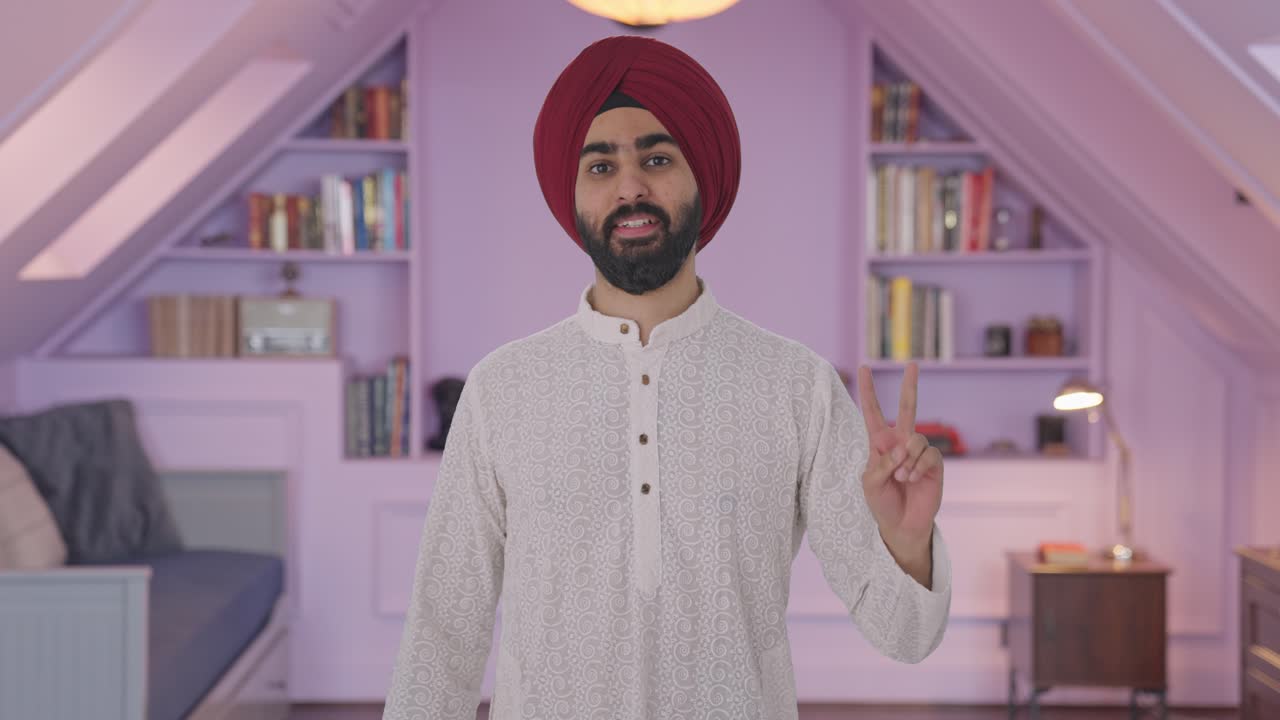 Uomo indiano Sikh che mostra il segno della vittoria
