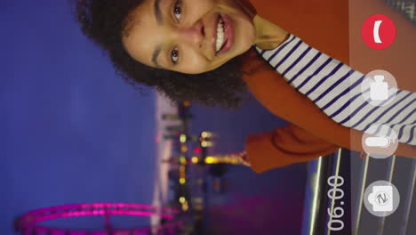 Vertical-video-of-woman-recording-video-vlog-of-herself-next-to-the-London-Eye-at-might-with-on-screen-controls---shot-in-slow-motion