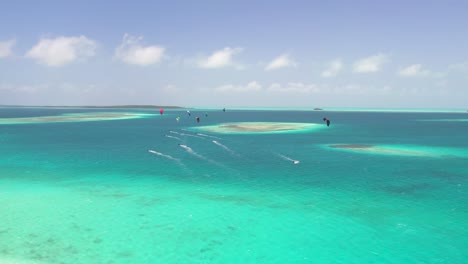 grupo de kitesurfistas viajando juntos a través de aguas tropicales