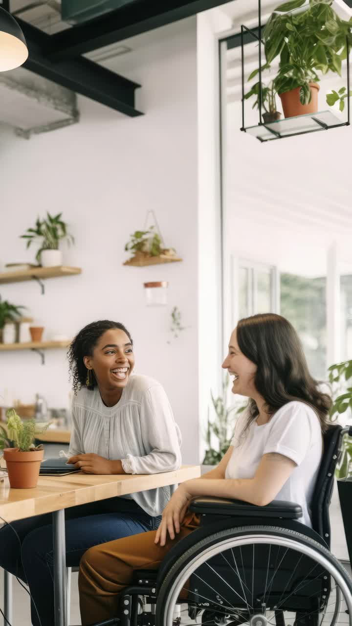 Warm, inclusive cafe scene video with two women, one in a wheelchair, chatting