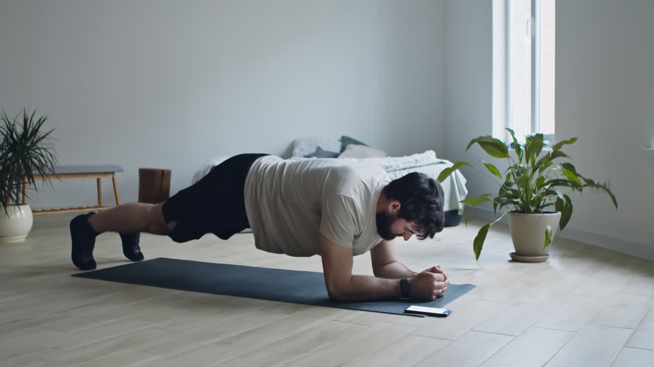 hombre haciendo un ejercicio de tabla en casa