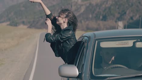 gorgeous-lady-in-leather-jacket-leans-out-of-car-window