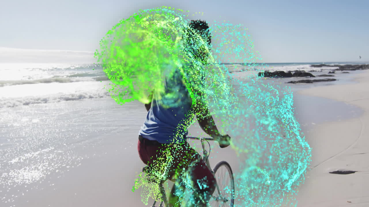 Man riding bicycle along beach, integrating digital particle overlays for technology marketing