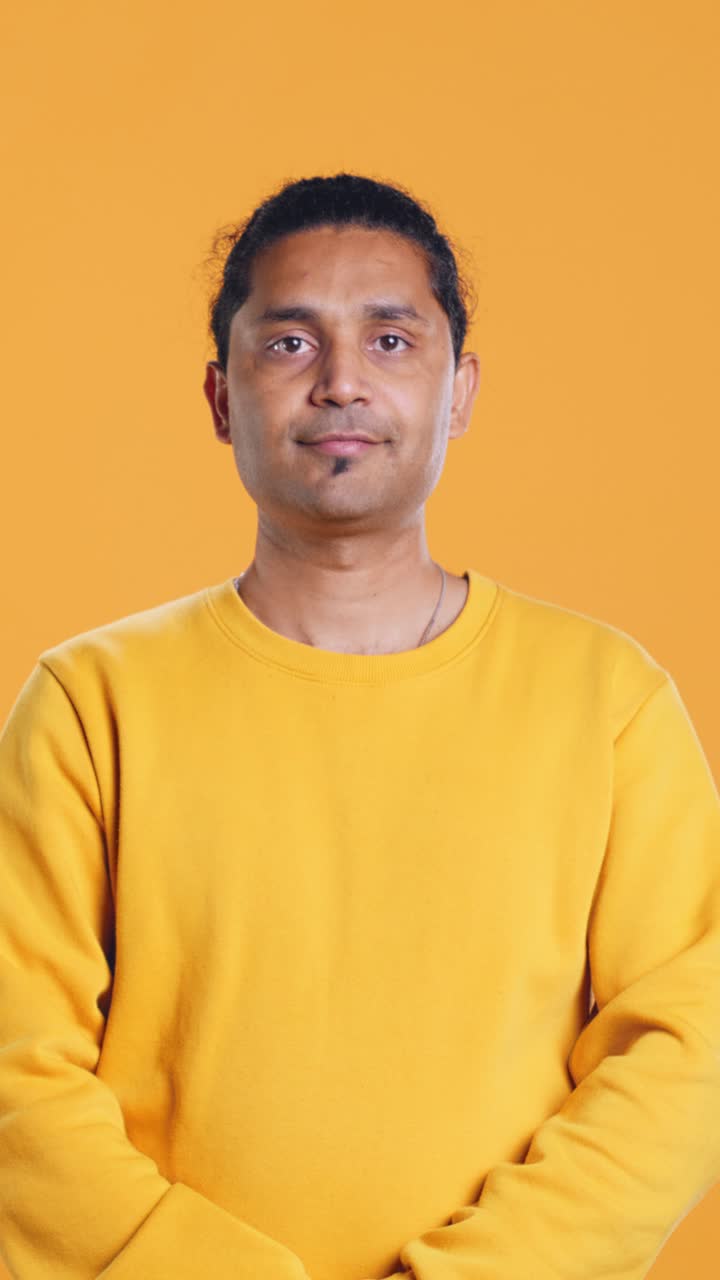 Confident Man Looking Up and Crossing Arms in Studio