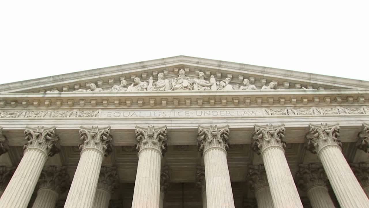 vista cercana de la escultura del frontón de entrada en el edificio de la corte suprema