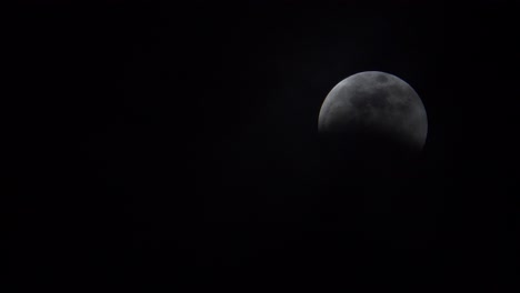 Thin,-wispy-clouds-moving-slowly-to-reveal-a-full-moon-during-a-lunar-eclipse