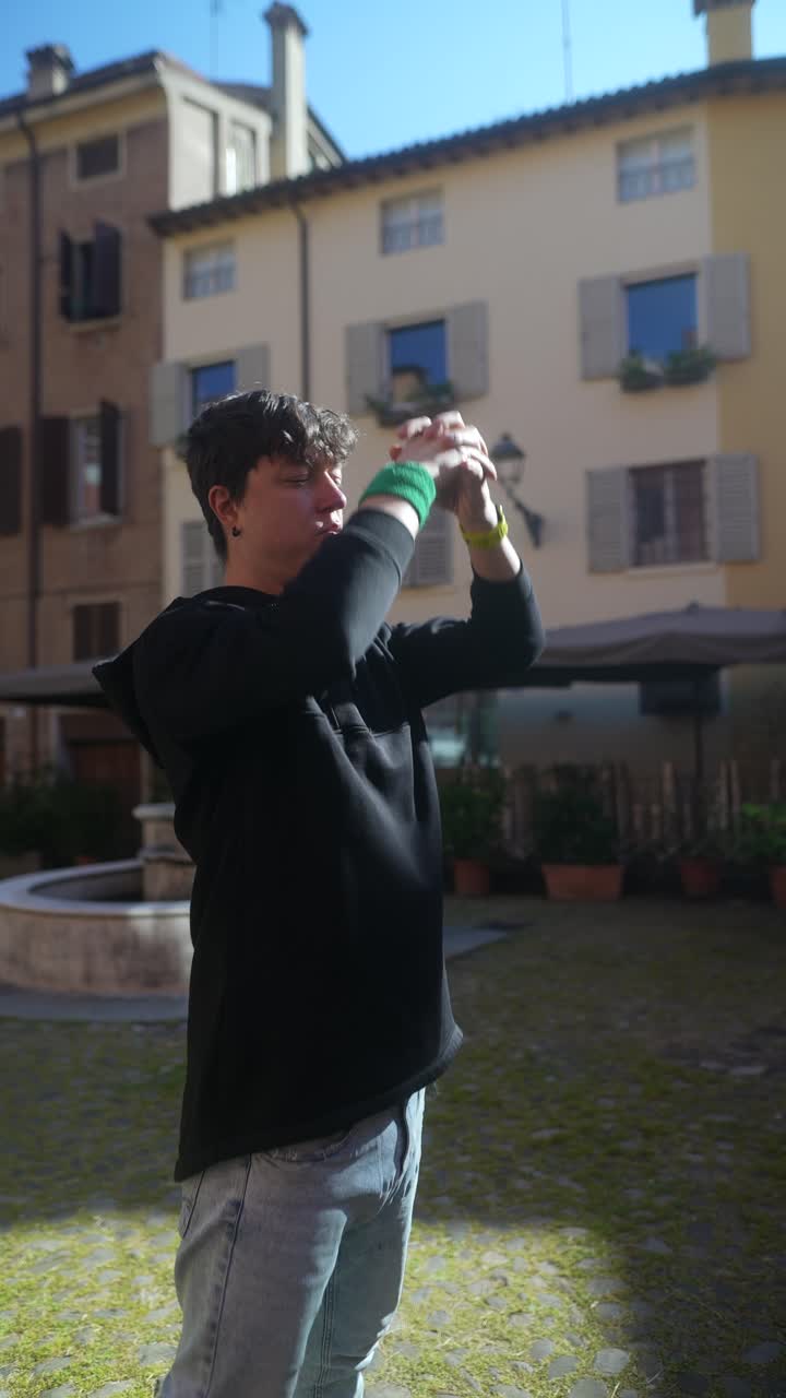 Giovane uomo in posa in una piazza italiana