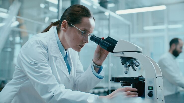 Female Scientist Adjusting Microscope while Conducting Laboratory Research