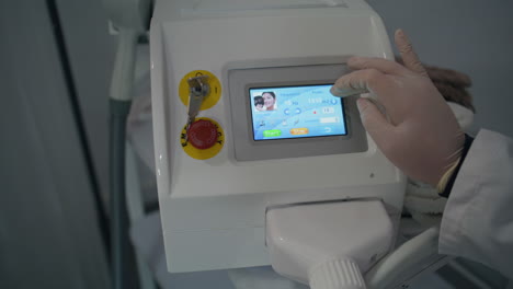 dermatologist touching procedure equipment closeup. hand touching selecting mode