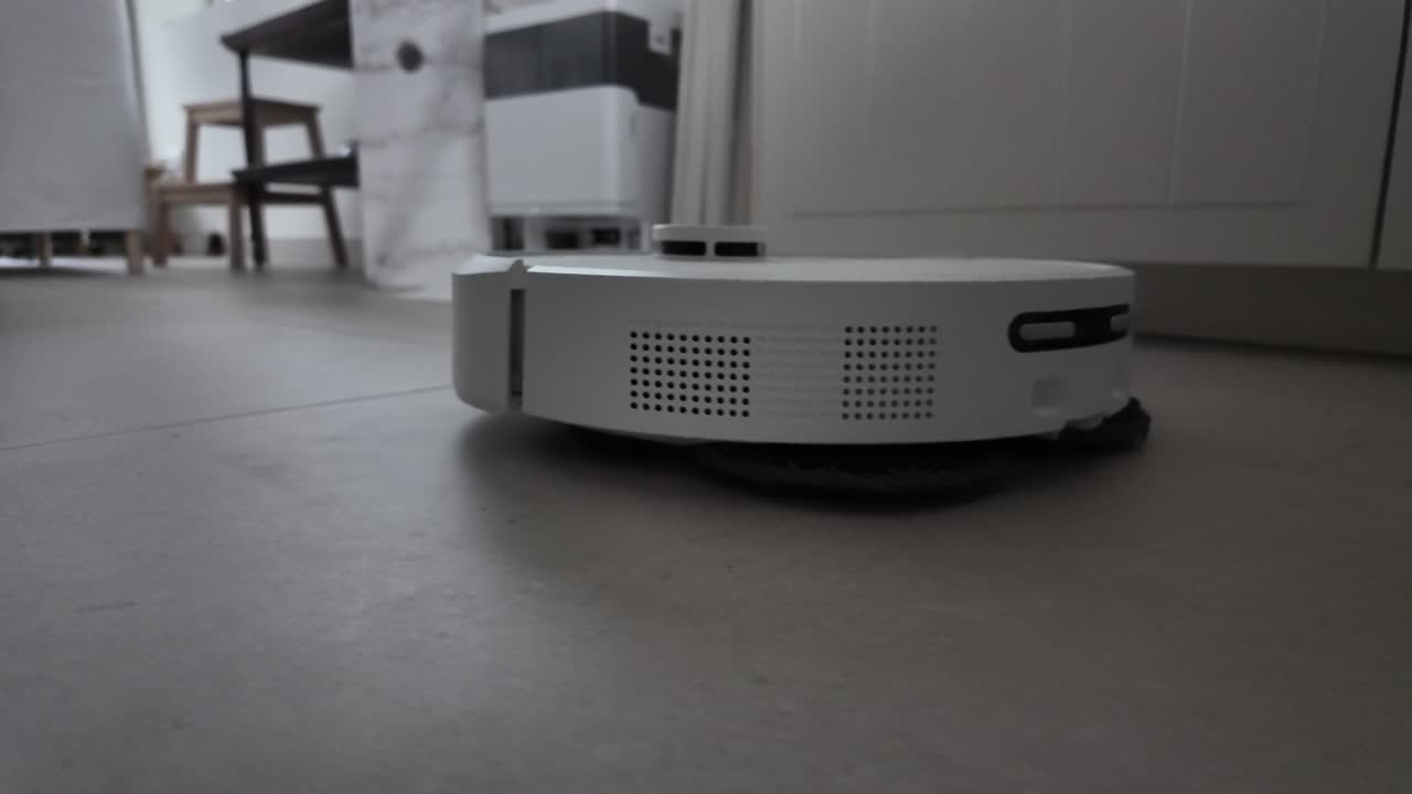 Close-up of a robotic vacuum cleaner moving across the floor in a home interior
