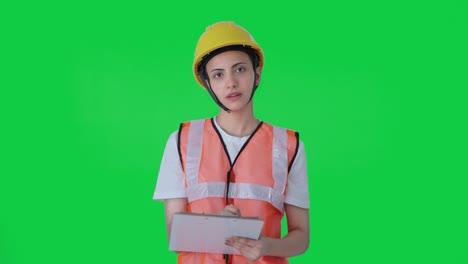 Indian-female-construction-worker-taking-notes-of-building-Green-screen