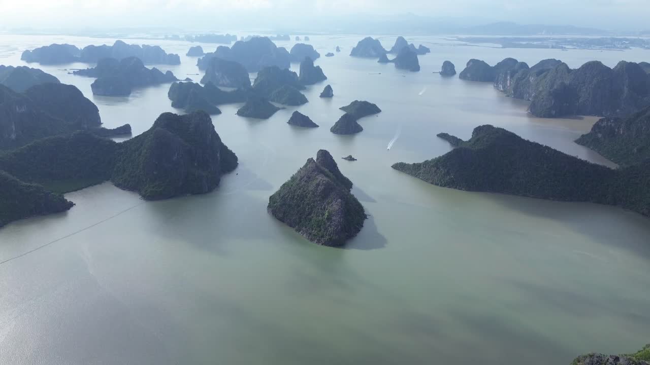 Elevating camera angle showing limestone peaks and lush forest in Cat Ba National Park