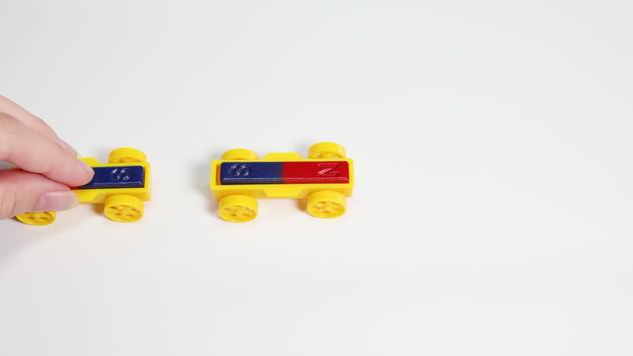 Hands manipulate colorful toy cars with magnets, illustrating magnetic attraction and repulsion on a white background