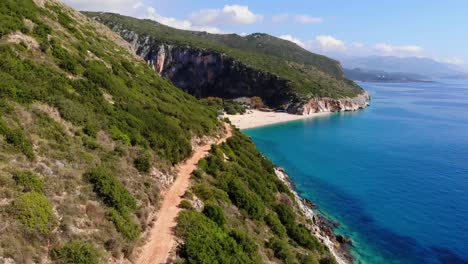 Couple-walks-up-a-path-that-leads-to-Gjipe-beach