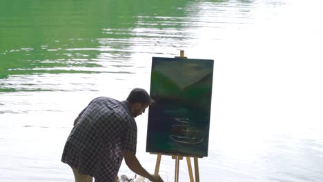 painter who paints against the lake. peaceful.