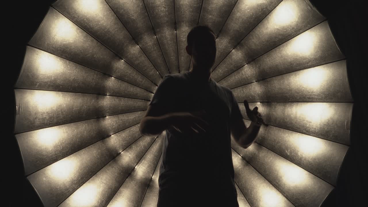 una persona con camisa y haciendo gestos de rap ante el gran paraguas de atención