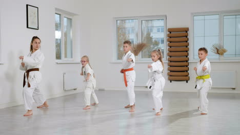niños en kimono blanco en la clase de artes marciales