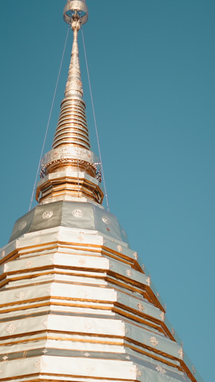 Stupa buddista dorato e argentato riccamente decorato contro il cielo blu