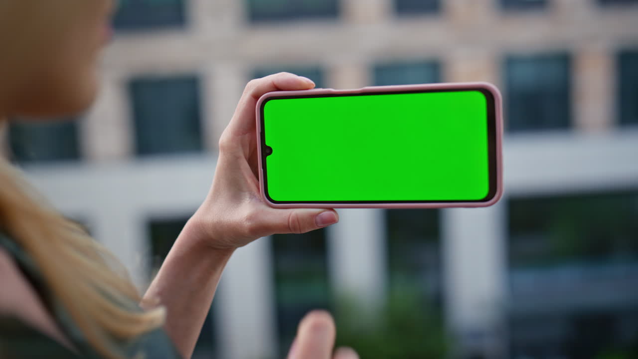 Businesswoman finger tapping chroma key cellphone at modern district closeup