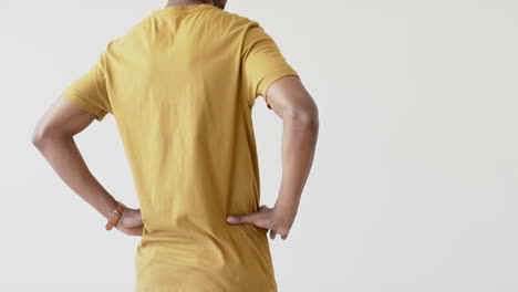 sección media de un hombre afroamericano vestido con una camiseta amarilla con espacio de copia en fondo blanco
