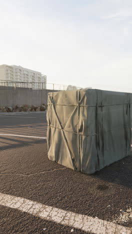 a large canvas crate is sitting on a paved street.