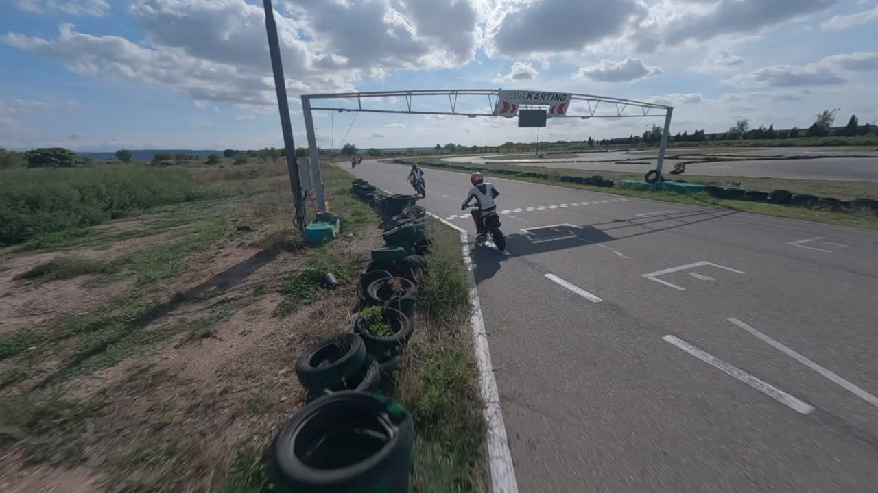 drone fpv aéreo después de la carrera de pit bike en carretera asfaltada, circuito de deportes de motor