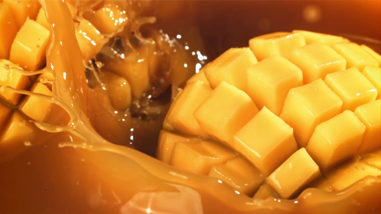 Cubetti di mango fresco che si tuffano in succo dorato
