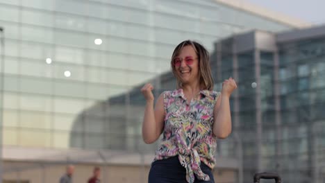 mujer turista alegre mostrando el gesto del sí con los brazos levantados, emocionada por el éxito celebrando la victoria