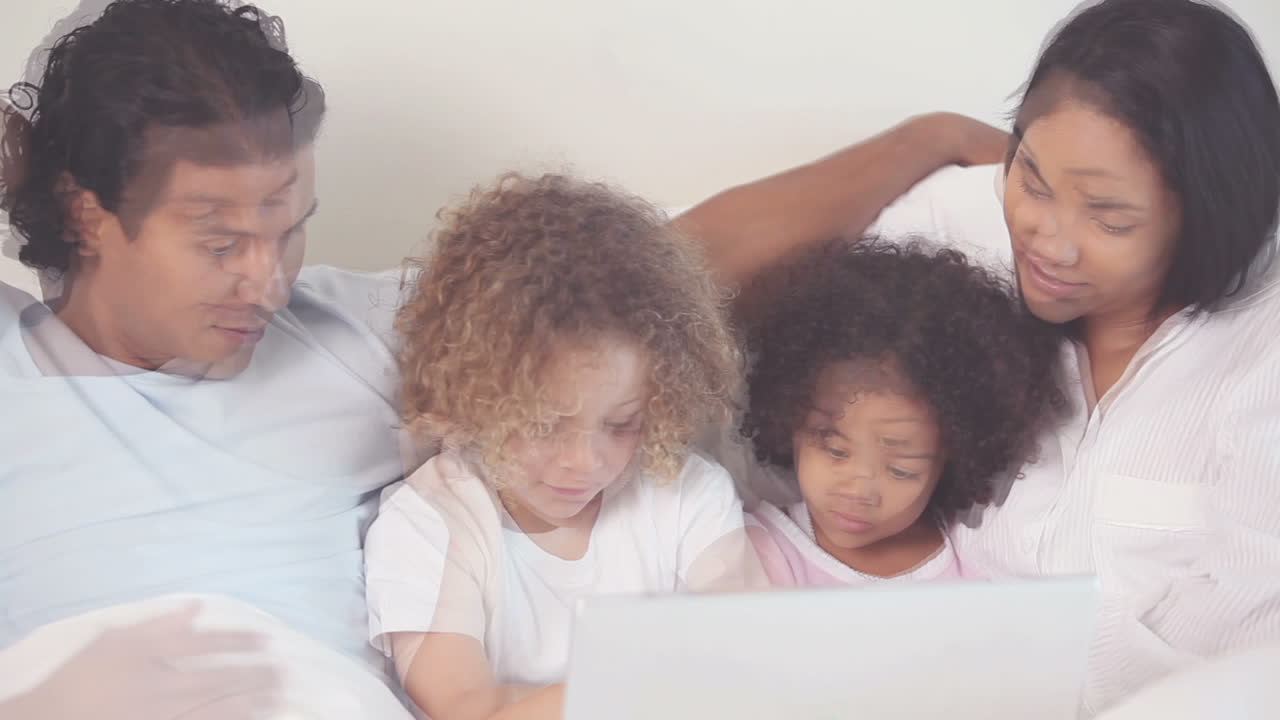 Famiglia con laptop sul letto