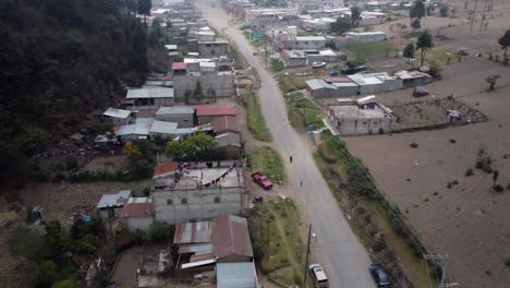 Low-aerial-follows-dirt-street-in-rural-Guatemala-mountain-village
