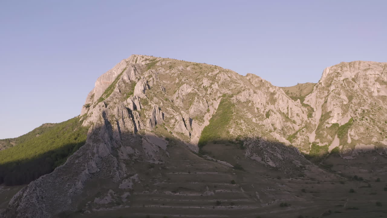 la luz del sol matinal ilumina la mitad superior de piatra secuiului, rumania, cerca de las aldeas de rimetea y pietroasa.