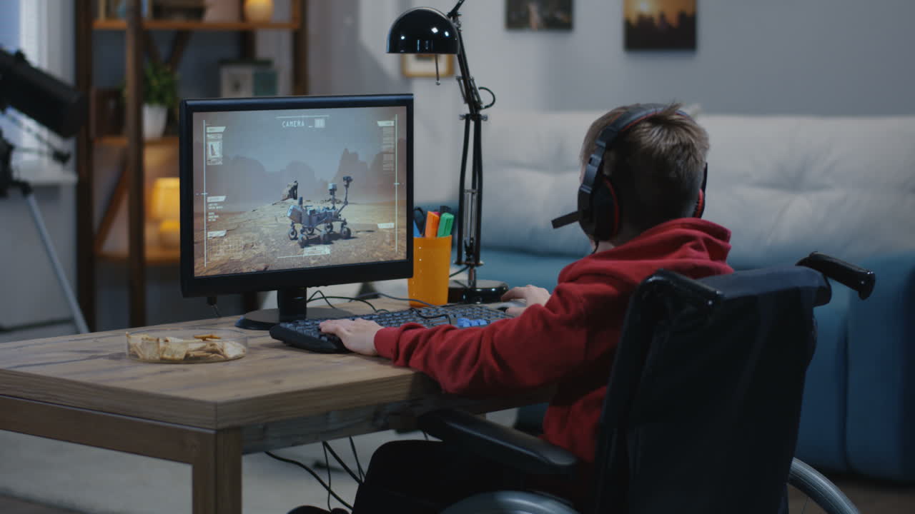 Boy in Wheelchair Playing a Space Video Game