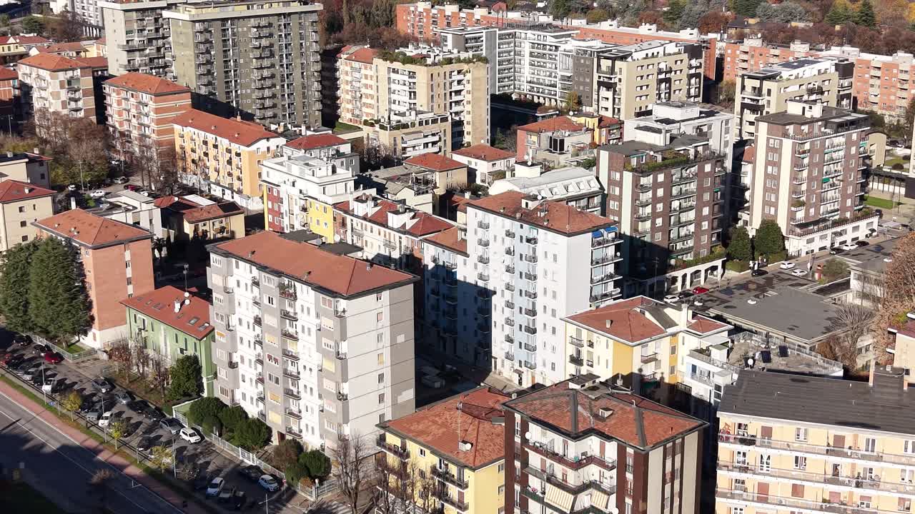 Cityscape Under a Clear Sky. An elevated view of a bustling urban landscape, showcasing a city architectural diversity, from residential buildings to commercial structures. San Donato Milanese, Italy