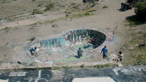 skateboarding in a graffiti-covered abandoned desert pool