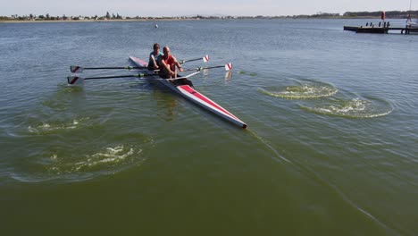 senior caucasian man and woman rowing boat on a river