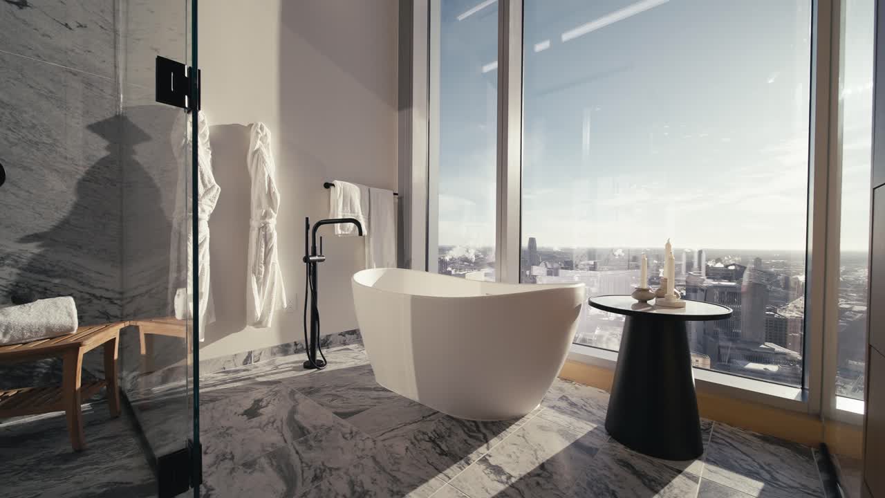 a gorgeous luxury bathroom with a white free standing tub and a side table in a high rise condo