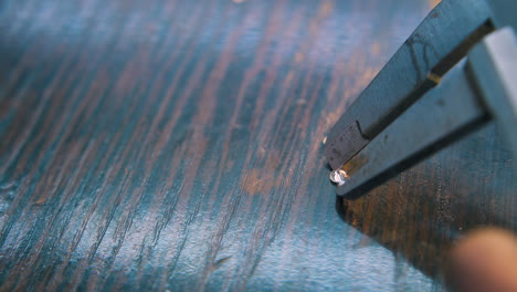 jeweler measures diamonds with sliding ruler closeup