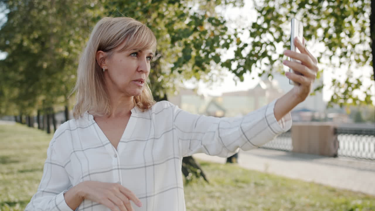una mujer tomando una selfie en un parque.