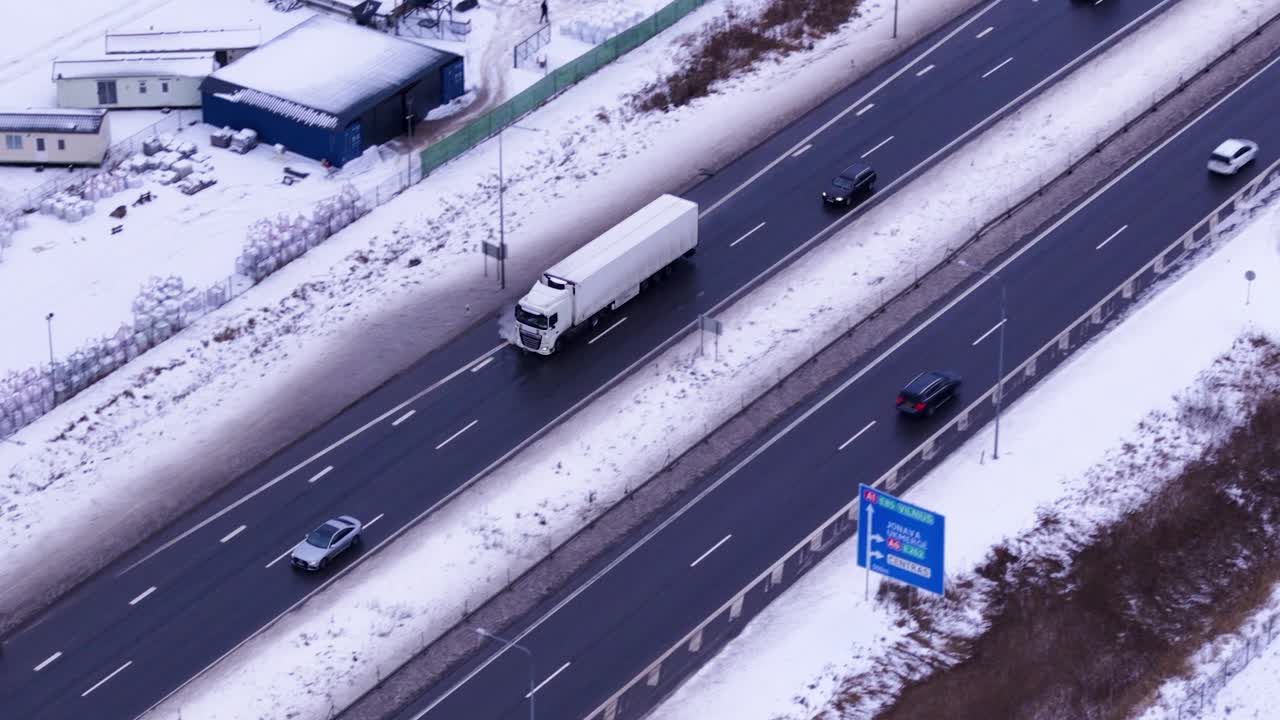 Фура перевозит груз в зимнее время года, вид с воздуха с дрона.