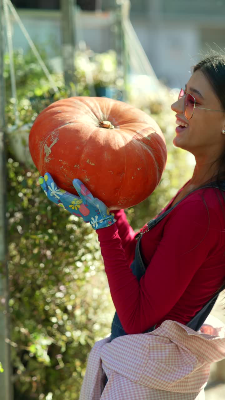 mujer sosteniendo una gran calabaza